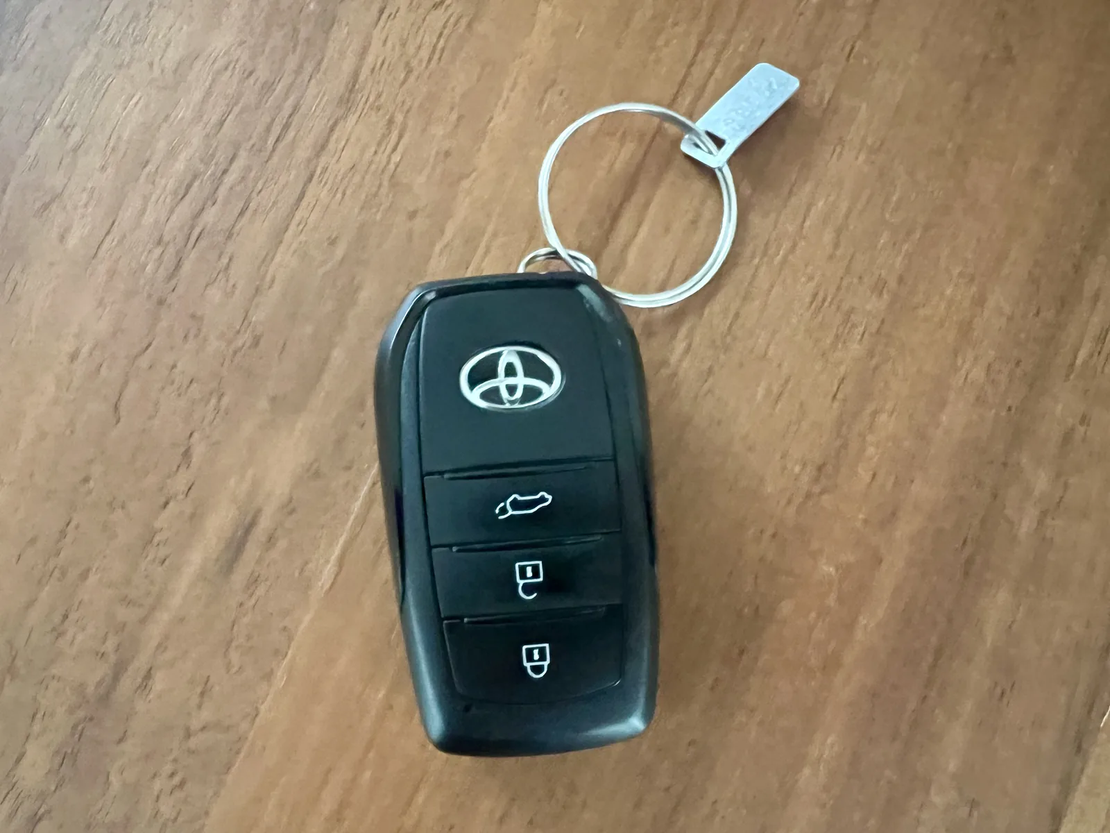 現在使用している80系ハリアーの別のスマートキーを木製テーブル上で撮影